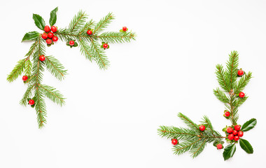 Christmas composition  with branches of spruce and holly with red berries on white background. Merry christmas greeting card with empty space for holiday text.