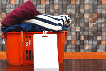 Wall Mural - clothes in orange basket or box with blank card, donation concept