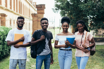 Wall Mural - Full length of happy african college students walking together on campus