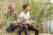 © Pixel-Shot - Young man and his father fishing on river