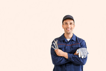 Wall Mural - Male car mechanic on color background