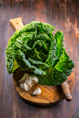 Wall Mural - Fresh raw savoy cabbage on wooden background