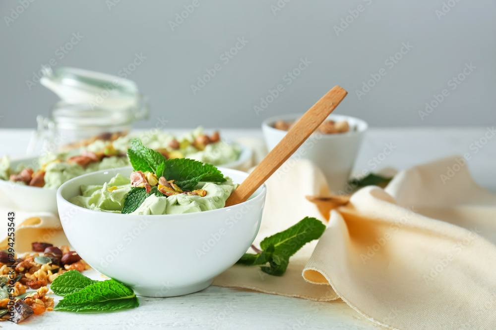 Bowl with tasty pistachio ice cream on table