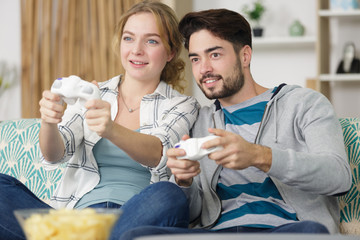 husband and wife plays video games with joysticks