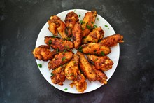 Fried Chicken Wings. Chicken Wings On A Dark Background. Barbecue Meat, Grill. Sauce In Bowls, Ketchup, Mayonnaise, Mustard, Cheese Sauce. Appetizing Fried Meat In The White Plate. Bowl.
