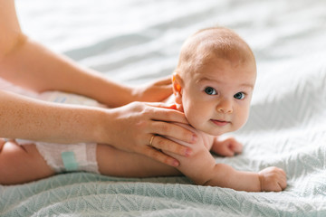massage for the baby. four month old baby smiling doing gymnastics