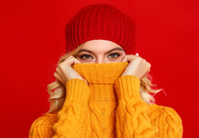 Happy Emotional Cheerful Girl Laughing  With Knitted Autumn Cap  On Colored Red Background