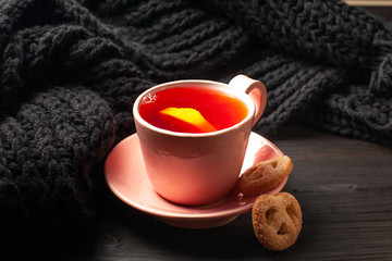 A cup of tea with lemon on dark background