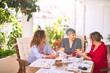© Krakenimages.com - Meeting of middle age women having lunch and drinking coffee. Mature friends smiling happy using smartphone at home on a sunny day