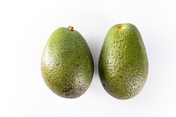 A composition of green, ripe avocados. Two whole avocado fruits, top view.