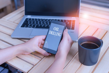 Poster - Writing note showing Oil Drilling. Business concept for involves the drilling and pumping of oil from underground wells woman with laptop smartphone and office supplies technology