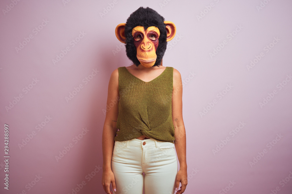 Woman standing wearing t-shirt and monkey mask