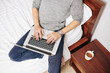 © DragonImages - Young man sitting on bed with cup of coffee and working and programming on laptop, view from above