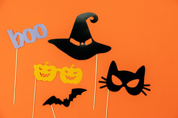 Fototapete - Table top view aerial image of decorations Happy Halloween day background holiday concept.Flat lay objects to party pumpkins photo booth prop and spider & bat hat witch on orange  paper wallpaper.