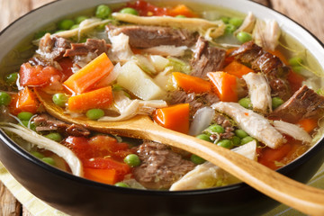  Booyah (booya, bouja, boulyaw, or bouyou) is a thick stew with vegetables and meat close-up in a bowl. horizontal