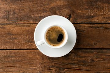 Wall Mural - Overhead shot of hot coffee cup on wooden background with copyspace