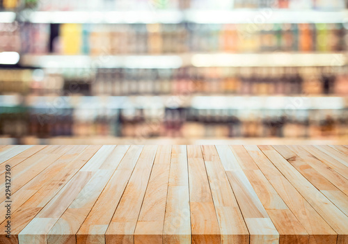 Fotomural Wood table top on blur of drinking product shelf background in supermarket or g