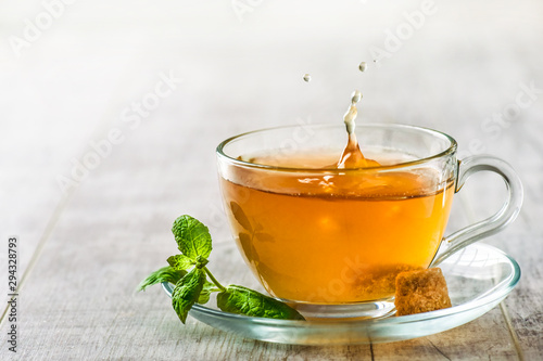 Green tea with brown sugar in clear glass. Tea splash splash from a cup.