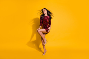 Full body photo of amazing lady with flying hairdo and perfect shapes dancing at disco party wear short shine red dress isolated yellow color background