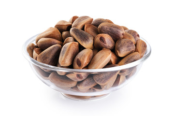 Wall Mural - Glass bowl with cedar pine nuts  isolated on white background.