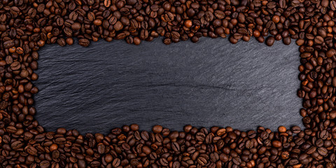 Wall Mural - Frame made of roasted coffee beans on black table, top view