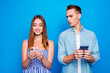 Portrait of his he her she two nice attractive lovely focused cheerful people using device spying on chatting messages isolated on bright vivid shine vibrant blue color background