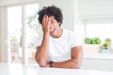 Sticker - Young african american man wearing casual white t-shirt sitting at home covering one eye with hand, confident smile on face and surprise emotion.