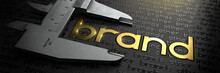 Business Concept With Golden Word BRAND On Black Background And Vernier Caliper.