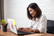 © suriya - young asian woman working  laptop computer on wood desk in Home office