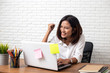 © suriya - Happy Asian young Businesswoman working laptop computer on wood desk in Home office