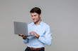 © Drobot Dean - Image of handsome businessman in office clothes holding laptop computer