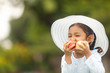 © prasit - beautiful children in a hat eating an apple on nature