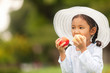 © prasit - beautiful children in a hat eats an apple on nature