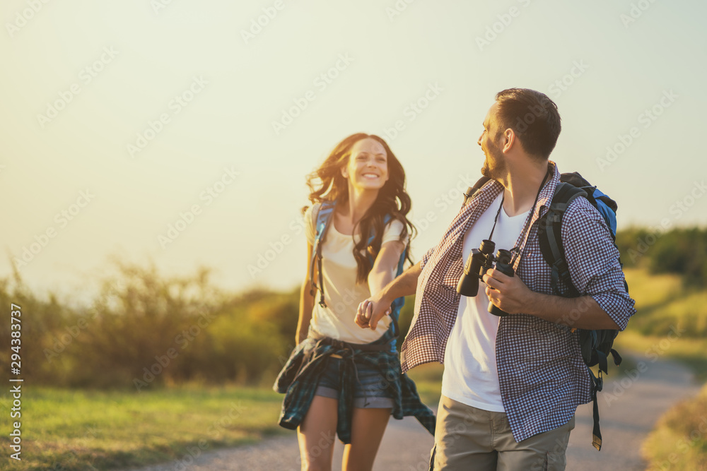 Happy couple is hiking in mountain. - obrazy, fototapety, plakaty 