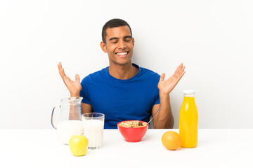 Young man having breakfast in a table laughing