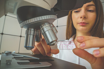 Wall Mural - student girl looking in a microscope, science laboratory concept