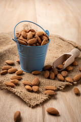 Wall Mural - Almonds in blue bucket. on wooden table. Almond concept with copyspace.