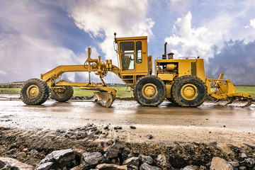 Canvas Print - Excavator to level and smooth the land in the construction of a road