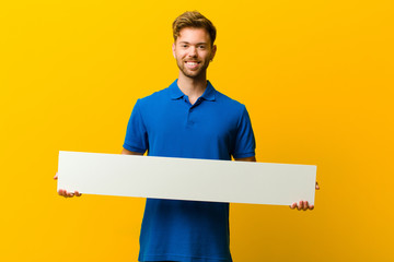 young man holding a placard against orange background