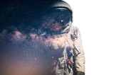 Fototapeta Kosmos - The double exposure image of the astronaut's suit overlay with the milky way galaxy image. the concept of imagination, technology, future, and gaming.