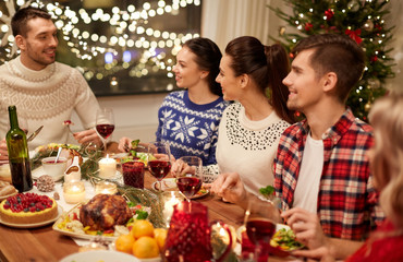 Sticker - holidays and celebration concept - happy friends having christmas dinner at home and eating