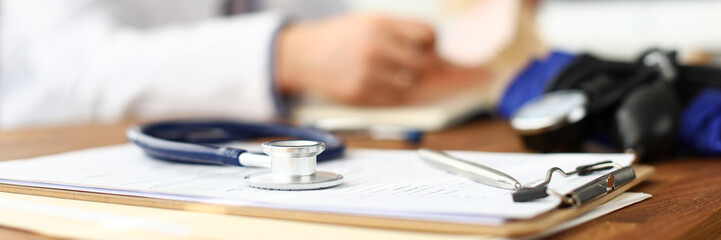 Wall Mural - Stethoscope head lying at worktable over patient medical history paper