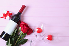 Wine And Glasses And Hearts On A Colored Background Top View. Background To The Day Of St. Valentine.