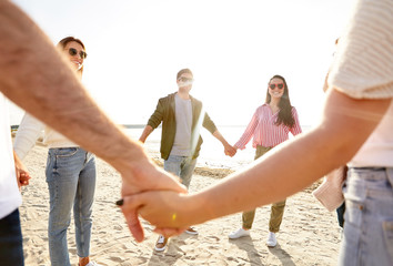 Sticker - friendship, leisure and people concept - group of happy friends holding hands on beach in summer