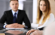 © Iryna - Business people or lawyers discussing questions of contract at meeting in modern office, close-up. Unknown businessman and woman with colleague sitting and working at the glass desk. Teamwork and