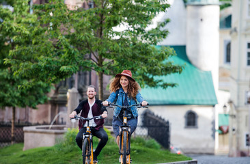 Wall Mural - young tourist couple travellers with electric scooters in small town.