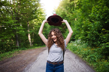 Wall Mural - young tourist woman traveller with backpack walking in nature.