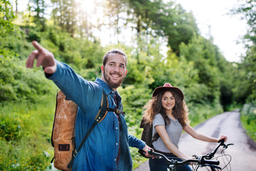 Wall Mural - young tourist couple travellers with electric scooters in nature.