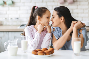 Mother and daughter touching noses and smiling to each other