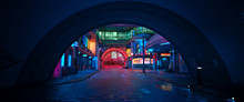 Street Of A Futuristic City, Starting With An Arch In A Tunnel. Photorealistic 3D Illustration. Night Scene With Neon Lighting. City Landscape In The Style Of Cyberpunk.